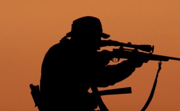 cazador mirando a traves del visor de su rifle